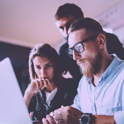 Three hyper focused team members working on optimizing a website for improved SEO