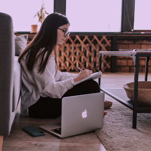 Younger woman sitting with laptop and creating a strategy for SEO & PPC